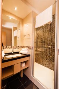 ein Bad mit einem Waschbecken und einer Dusche in der Unterkunft Premia Apartments Konaci in Kopaonik