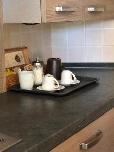 a black tray with two mugs on top of a kitchen counter at Mountain Suite in Raveo