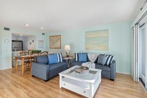 ein Wohnzimmer mit 2 blauen Stühlen und einem Tisch in der Unterkunft 1357 Pelican Watch in Seabrook Island