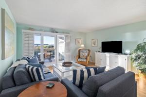ein Wohnzimmer mit einem Sofa und einem TV in der Unterkunft 1357 Pelican Watch in Seabrook Island