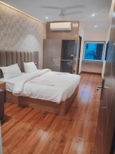1 dormitorio con 1 cama grande y suelo de madera en Hotel Sharma Regency, en Lucknow
