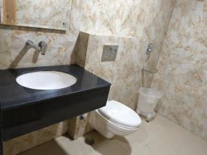 baño con lavabo negro y aseo en Hotel Sharma Regency, en Lucknow