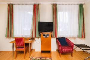 ein Wohnzimmer mit einem Tisch, 2 Stühlen und einem TV in der Unterkunft Ferien beim Steiner in Predlitz