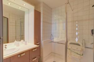 a bathroom with a shower and a sink and a mirror at Biscarrosse Bourg - Duplex avec terrasse classé 3 étoiles in Biscarrosse