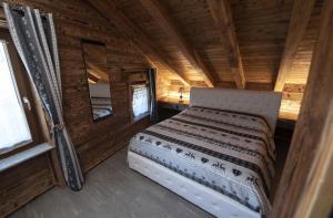 a bedroom with a bed in a log cabin at Les Tours in La Salle
