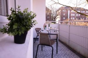 a table and chairs on a balcony with a plant at Modern und stilvoll zwischen Innenstadt und Rü in Essen