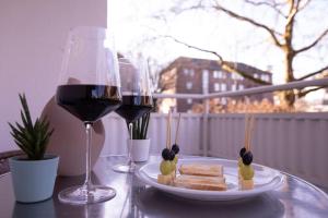 a glass of wine and a plate of bread and wine glasses at Modern und stilvoll zwischen Innenstadt und Rü in Essen