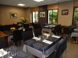 a dining room with tables and chairs with blue and white table settings at Le Gardy in Arques +17 photos