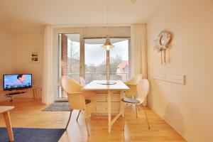 uma sala de jantar com uma mesa e cadeiras e uma janela em Wohnpark am Mühlenteich Wohnpark am Mühlenteich Appartement 09 em Timmendorfer Strand