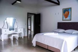 a bedroom with a white bed and a white table at Pousada Sabores do Mar Laranjeiras in Balneário Camboriú