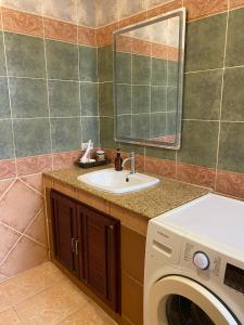 a bathroom with a sink and a washing machine at Samui Green Life in Bophut