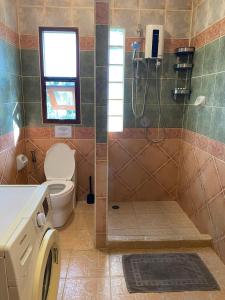 uma casa de banho com um WC e um chuveiro com uma máquina de lavar roupa em Samui Green Life em Bophut