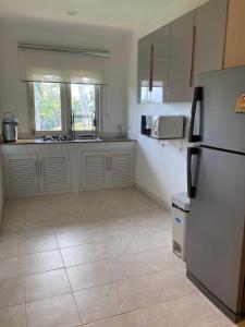 een keuken met witte kasten en een koelkast bij Samui Green Life in Bophut 