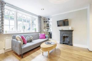 sala de estar con sofá y chimenea en Elegant Marylebone Hideaway, en Londres