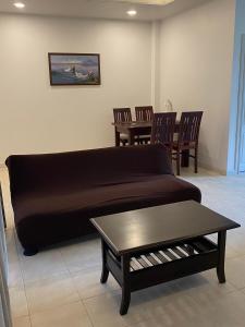 uma sala de estar com um sofá, uma mesa e cadeiras em Samui Green Life em Bophut