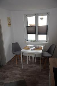 une chambre avec une table, deux chaises et une fenêtre dans l'établissement Wanderpfotens Ostsee Ferienhaus, à Tribsees