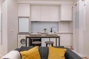 ein Wohnzimmer mit einem Sofa und einer Küche in der Unterkunft Ponzano Foodie Encanto Madrileño in Madrid