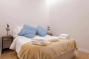 - une chambre avec un lit et des serviettes dans l'établissement Ponzano Foodie Encanto Madrileño, à Madrid