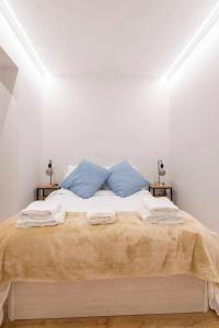 - une chambre blanche avec un lit et des oreillers bleus dans l'établissement Ponzano Foodie Encanto Madrileño, à Madrid