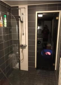 a man taking a picture of a shower in a bathroom at Meewella in Rovaniemi