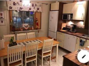 a kitchen with a wooden table and chairs in a kitchen at Lapland Second Home in Rovaniemi