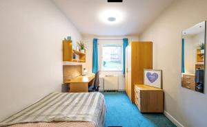 Schlafzimmer mit einem Bett, einem Schreibtisch und einem Fenster in der Unterkunft Modern City Living Apartments at Broadgate Park in Nottingham in Nottingham