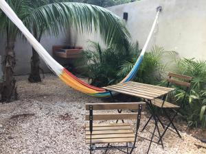 una hamaca y 2 sillas en un patio en Villa Constantino en Telchac Puerto