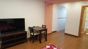 a living room with a dining table and a television at Apartamenticos Boggiero I in Zaragoza