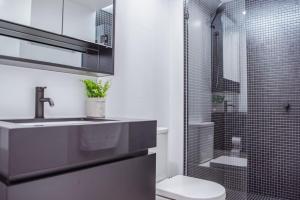 a bathroom with a sink and a shower with a toilet at Ideal Cozy 1BR for your Urban Escape in Gabba in Brisbane