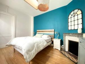 1 dormitorio azul con 1 cama y chimenea en Villa familiale à Arcachon plage, en Arcachon