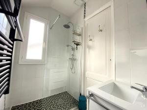 a white bathroom with a shower and a sink at Villa familiale à Arcachon plage in Arcachon