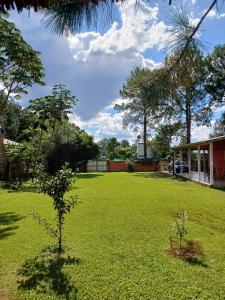 a green yard with a small tree in front of a house at Cabaña Carmela in Garupá