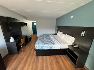 ein Hotelzimmer mit einem Bett und einem Schreibtisch in der Unterkunft Motel 6 East Syracuse, NY - Airport in East Syracuse
