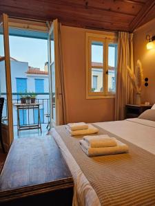 een slaapkamer met een bed met twee handdoeken erop bij Kallisti Luxury rooms in Nafplio