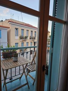 a balcony with a table and a view of a building at Kallisti Luxury rooms in Nafplio