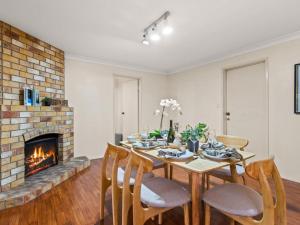 a dining room with a table and chairs and a fireplace at 5Mins walk to mall 4BR Family home nicely located in Brisbane
