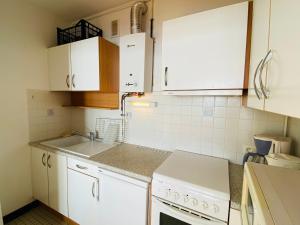 レ・サ​​ーブル・ドロンヌにあるAppartement Les Sables-d'Olonne, 1 pièce, 3 personnes - FR-1-92-607の白いキャビネットとシンク付きのキッチン