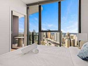 a bedroom with a white bed with a view of a city at River and Ocean View Luxury 2BD Apt amazing Location in Gold Coast