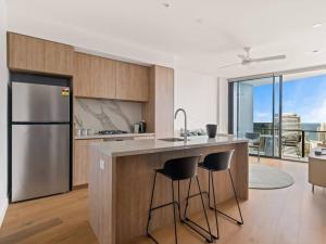a kitchen with a stainless steel refrigerator and a counter at River and Ocean View Luxury 2BD Apt amazing Location in Gold Coast