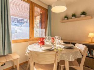 ヴァルモレルにあるAppartement Valmorel, 2 pièces, 6 personnes - FR-1-291-714のダイニングルームテーブル(白いテーブルクロス付)