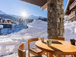 a table and chairs with a view of snow covered mountains at Appartement Valmorel, 2 pièces, 6 personnes - FR-1-291-714 in Valmorel