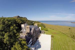 an aerial view of a large house on a hill next to the water at Flodigarry Hotel and SKYE Restaurant in Staffin