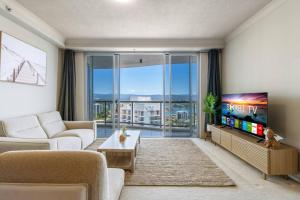 a living room with a tv and a large window at Stunning riverview 2BR holiday apt good location in Gold Coast