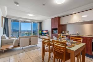 a kitchen and living room with a table and chairs at Stunning riverview 2BR holiday apt good location in Gold Coast