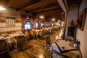 a dining room with tables and chairs in a restaurant at Pensiune Restaurant Lyra in Corunca