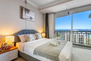 a bedroom with a bed and a large window at Stunning riverview 2BR holiday apt good location in Gold Coast