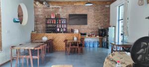 a restaurant with tables and chairs and a tv on a brick wall at Jiannanshan Garden Homestay in Kunming