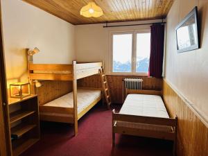 ラルプ・デュエズにあるAppartement Huez, 2 pièces, 4 personnes - FR-1-405-22のベッドルーム1室(二段ベッド2台、窓付)が備わります。