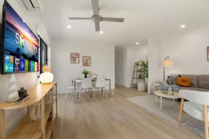 uma sala de estar com um sofá e uma mesa em 3BR home with cozy interior design em Browns Plains