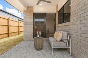 a patio with a couch and a table at 3BR home with cozy interior design in Browns Plains